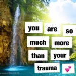 Macro format image of text reading "you are so much more than your trauma [heart emoji]" in black font on white background overlaid on a photograph of a clear blue waterfall down a cliff with greenery and sky in the background